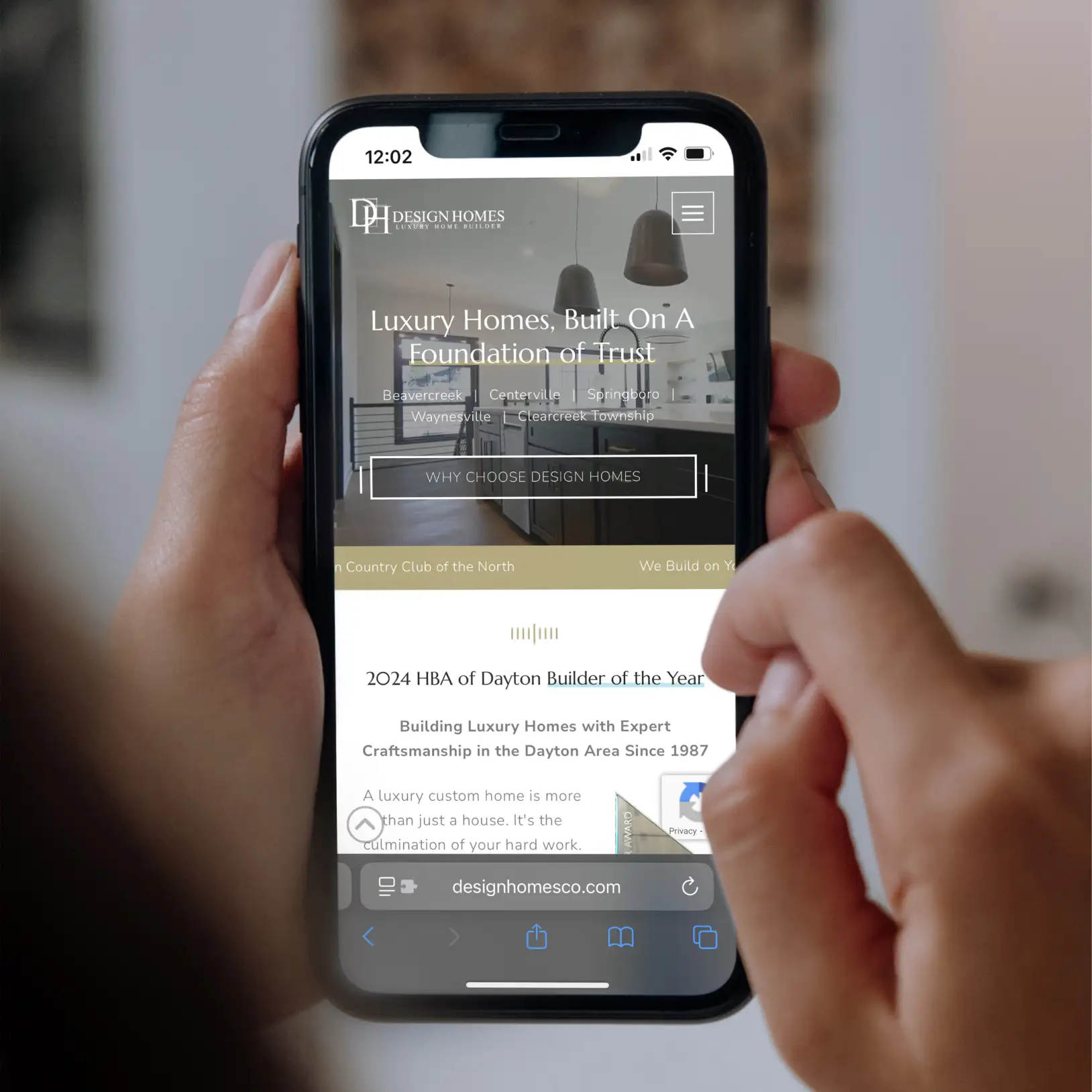 Design Homes Luxury Home Builder website being viewed on a mobile phone